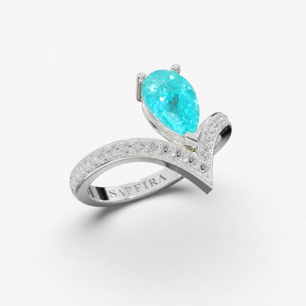 A silver ring featuring a pear-cut paraiba gemstone and a curved pavé band engraved with 'SAPFIRA', shown on a clean white background.
